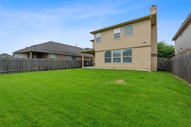Rear view of property featuring a fenced backyard and a chimney | Image 39