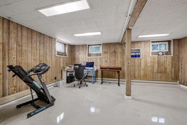 Office with wooden walls and baseboard heating | Image 13