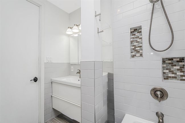 Full bath with vanity, tile walls, and washtub / shower combination | Image 15