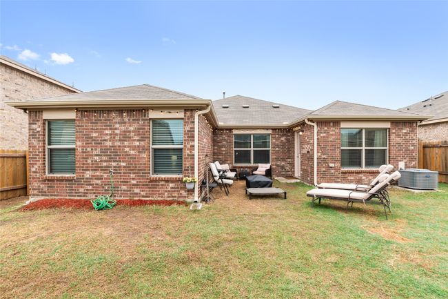 Rear view of house with fence, central AC unit, an outdoor living space, brick siding, and a lawn | Image 31