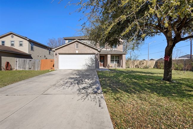 Traditional-style house featuring fence, an attached garage, a front yard, brick siding, and driveway | Image 4