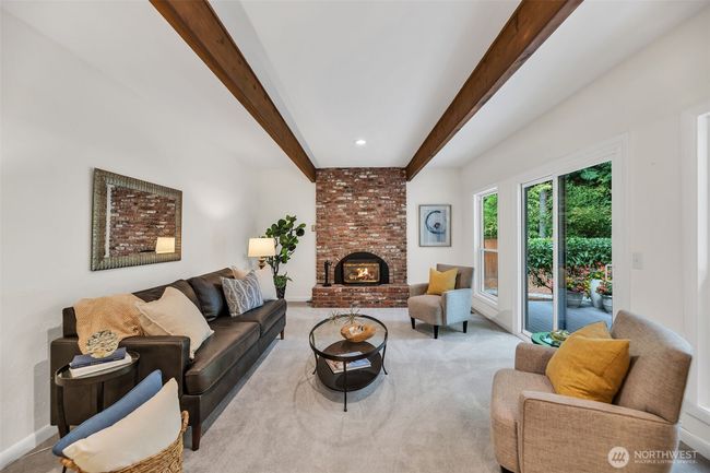 Bright and cheery family room with wood beamed ceiling and slider leading to huge entertainment deck. | Image 14