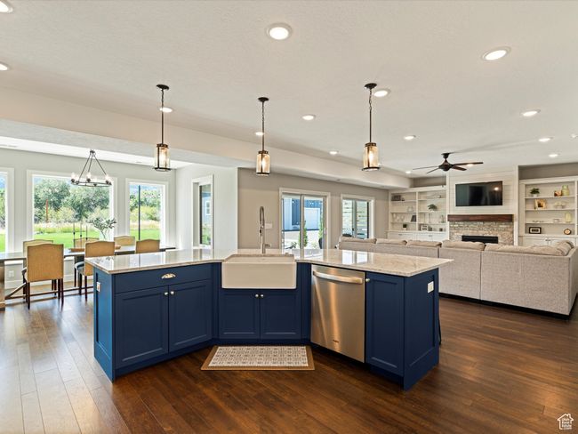 Kitchen featuring stainless steel dishwasher, a sink, blue cabinetry, ceiling fan, and plenty of natural light | Image 7