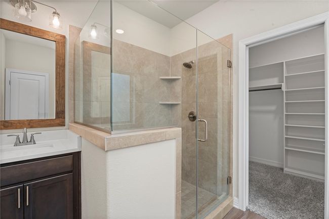 Bathroom with a shower stall, a walk in closet, and vanity | Image 20