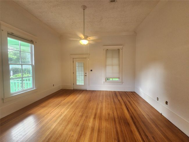 Empty room featuring a textured ceiling, light wood-style flooring, and ceiling fan | Image 17