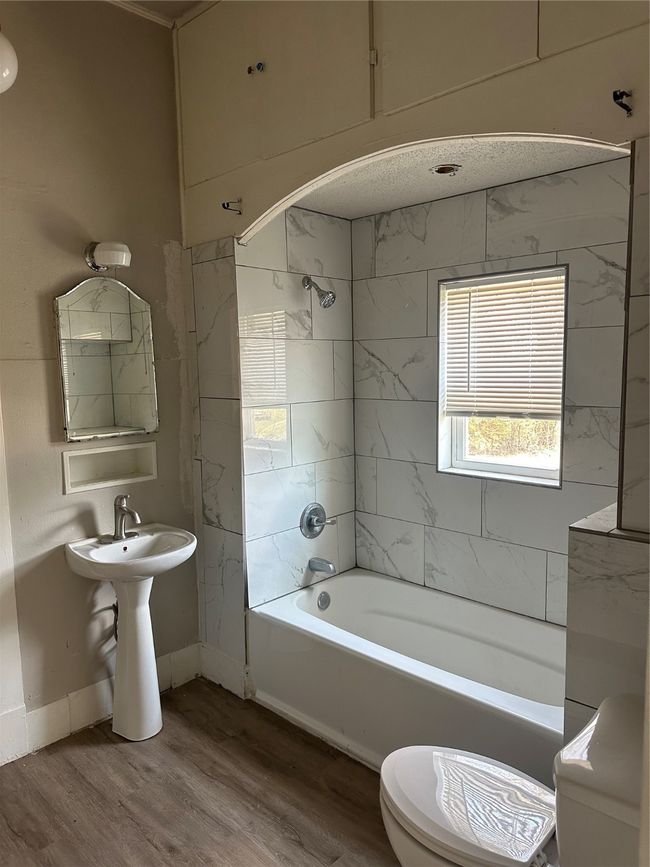 Full bathroom featuring toilet, shower / tub combination, wood finished floors, and baseboards | Image 8