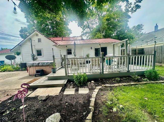 back of property featuring a hot tub, a metal roof, and a wooden deck | Image 9