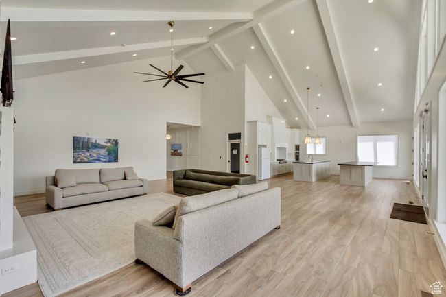 Living room with beamed ceiling, high vaulted ceiling, light wood-style floors, and recessed lighting | Image 35