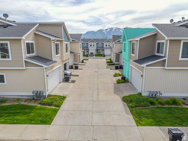 View of property's community featuring a residential view, an attached garage, a mountain view, and concrete driveway | Image 37