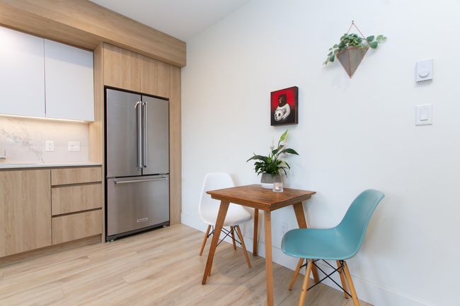 Kitchen featuring high end fridge, modern cabinets, light countertops, and light wood-style flooring | Image 7