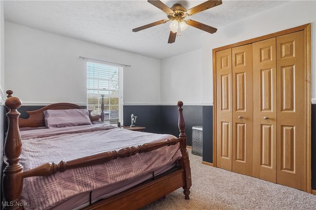 Carpeted bedroom featuring a textured ceiling, ceiling fan, and a closet | Image 35
