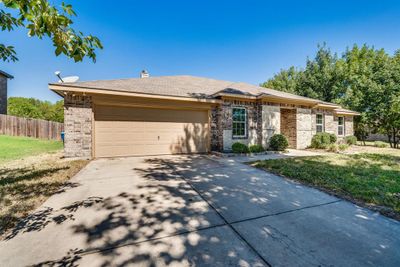 Ranch-style home with a garage and a front yard | Image 1