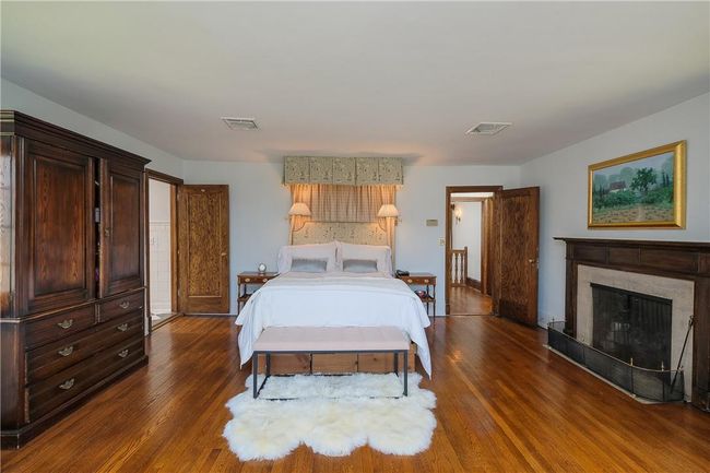 Primary bedroom, dual walk-in closets, fireplace, oak floors, en-suite renovated primary bath | Image 18