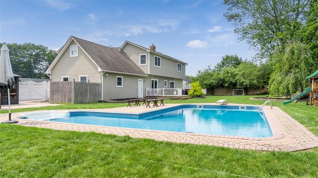 View of swimming pool featuring a playground and a gate | Image 4
