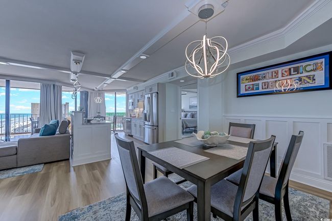 Dining room featuring crown molding, a notable chandelier, and light hardwood / wood-style floors | Image 11