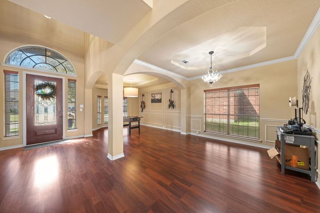 Entryway with a decorative wall, arched walkways, a notable chandelier, and wood finished floors | Image 14