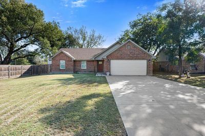 Ranch-style home with a front yard and a garage | Image 3