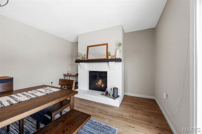 Living area featuring LVP floors and a wood burning brick fireplace | Image 16