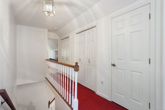 Upstairs hall features a wall of closets for abundant storage | Image 32
