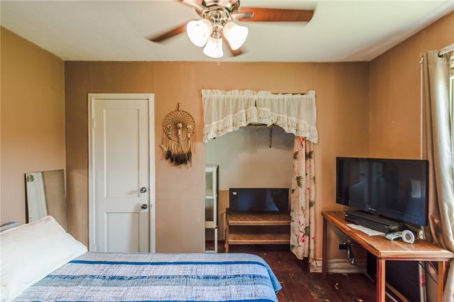 Bedroom with wood finished floors and ceiling fan | Image 21