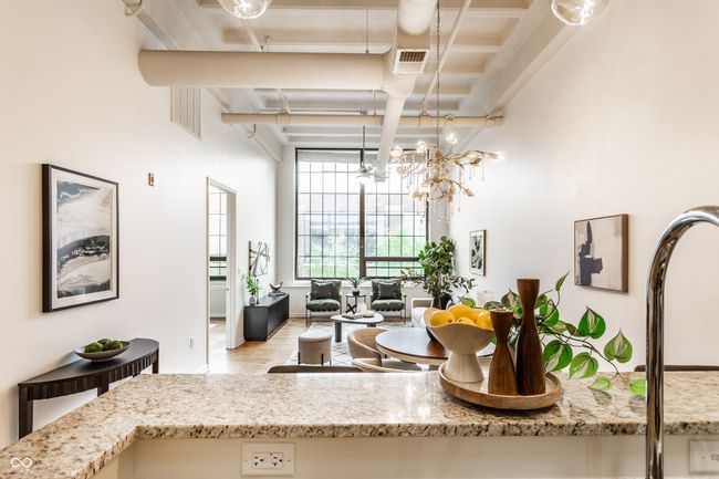 kitchen featuring beamed ceiling, a chandelier, and light stone countertops | Image 17