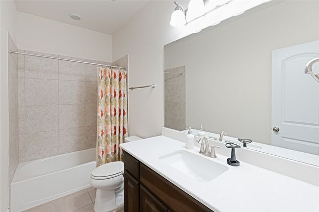 Full bath featuring vanity, tile patterned flooring, and shower / bath combination with curtain | Image 33