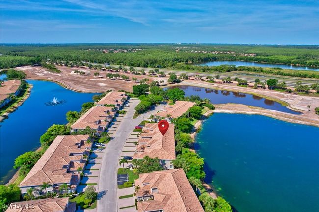 Aerial view of a the home, the surrounding water and of the golf course under renovation and the wooded area in the community | Image 50