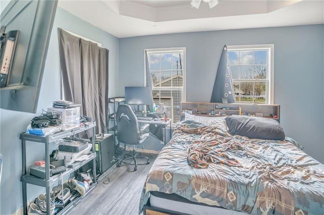 Bedroom with a raised ceiling and wood finished floors | Image 10