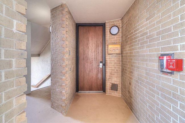 Front door to 401, with stairs leading down to pool area. | Image 37