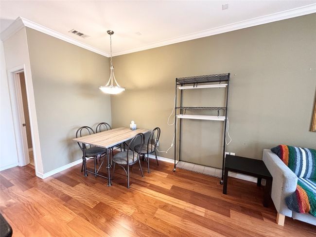Dining area with wood finished floors, ornamental molding, and baseboards | Image 9