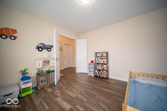 bedroom featuring dark vinyl flooring with wood appearance and baseboards. French doors and a closet were added to make this versatile room into a 4th bedroom. It can easily be used as an office, dining room, or playroom. | Image 12