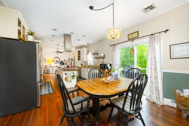 Dining room with dark wood finished floors, baseboards, a chandelier, ornamental molding, and recessed lighting | Image 8