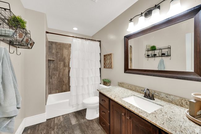 Full bathroom with vanity, wood finished floors, shower / bath combination with curtain, and recessed lighting | Image 14