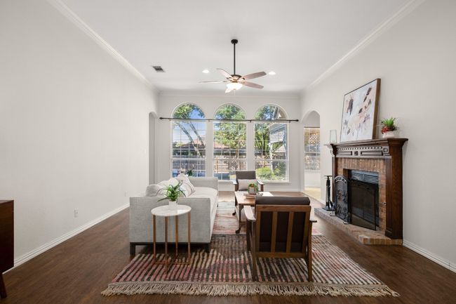 Living room with ornamental molding, a fireplace, dark wood-style flooring, recessed lighting, and a ceiling fan | Image 8