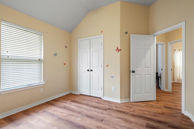 Unfurnished bedroom featuring wood finished floors, a closet, and vaulted ceiling | Image 33