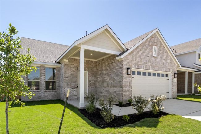 View of front of home featuring a garage, brick siding, a front lawn, and concrete driveway | Image 4