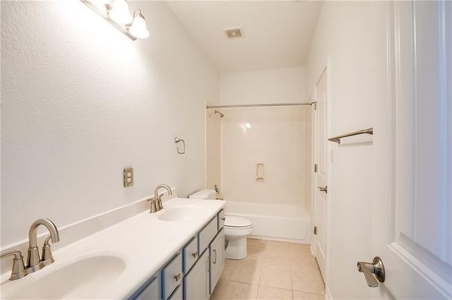 Full bathroom featuring tile patterned floors, double vanity, and shower / bathtub combination | Image 28