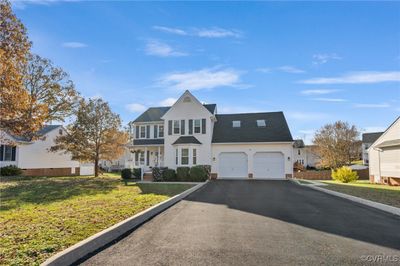 View of property with covered porch, a garage, and a front lawn | Image 3