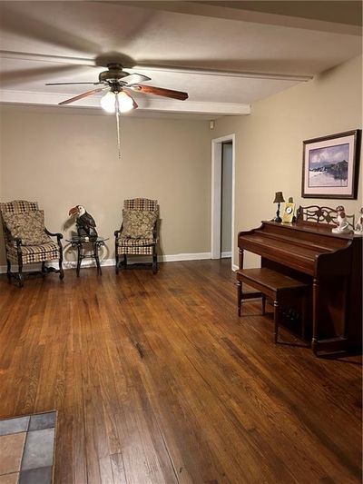 Living room room with ceiling fan and dark wood-type flooring | Image 2