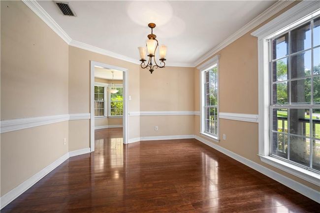 Spare room with a chandelier, hardwood / wood-style flooring, and crown molding | Image 14