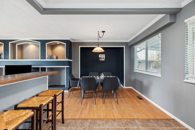Dining room with wood finished floors, baseboards, ornamental molding, and visible vents | Image 9