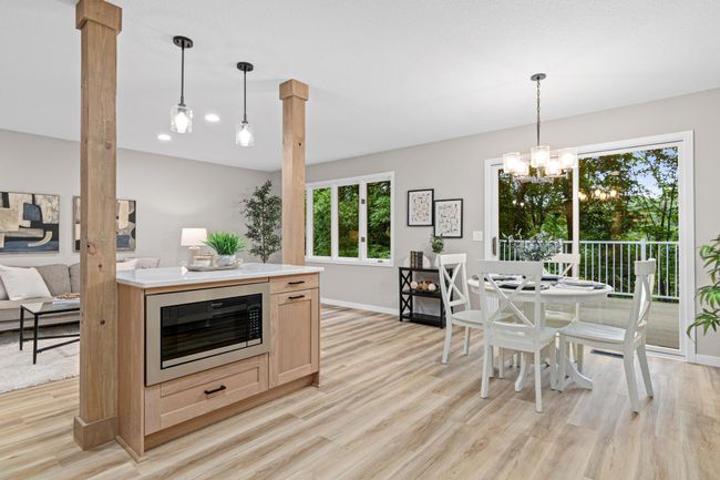 Enjoy seamless flow from the kitchen to the dining and living areas, with a patio door that opens to a maintenance-free deck—perfect for indoor-outdoor living. | Image 7