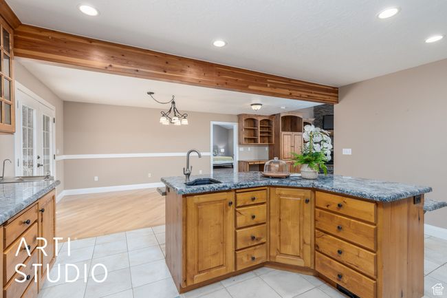 Kitchen with a sink, glass insert cabinets, recessed lighting, and dark stone counters | Image 22