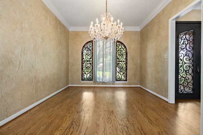 Dining room featuring wood floors, crystal chandelier, & ornamental windows | Image 5
