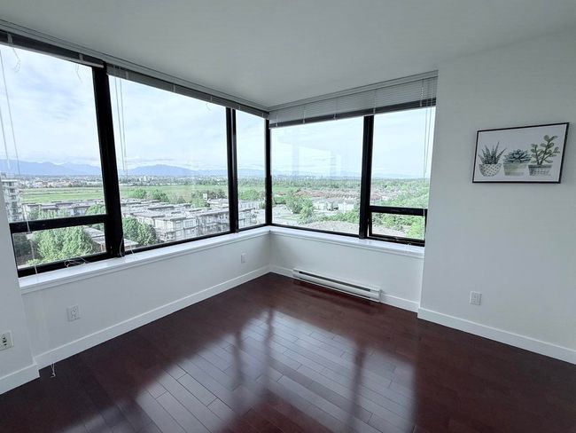 Empty room featuring a baseboard heating unit, dark wood finished floors, and a mountain view | Image 15