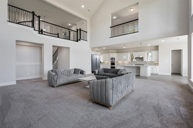 Living area with high vaulted ceiling, baseboards, stairs, and recessed lighting | Image 13