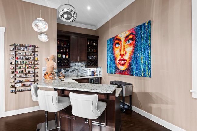 Bar featuring crown molding, wet bar, tasteful backsplash, baseboards, and dark wood-type flooring | Image 14