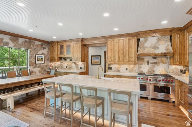 Kitchen featuring custom range hood, range with two ovens, tasteful backsplash, light wood-type flooring, and recessed lighting | Image 8