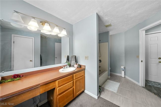 Bathroom with vanity, tub / shower combination, and a textured ceiling | Image 18
