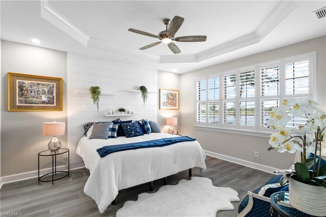 Bedroom with ornamental molding, a raised ceiling, wood finished floors, ceiling fan, and recessed lighting | Image 16